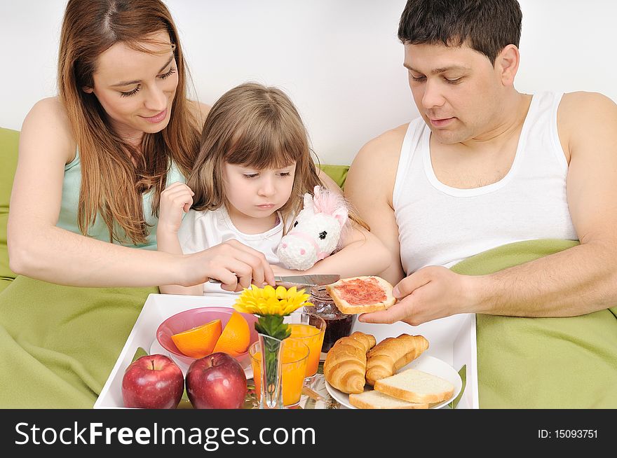 Happy young family at home relaxing in bed. Happy young family at home relaxing in bed