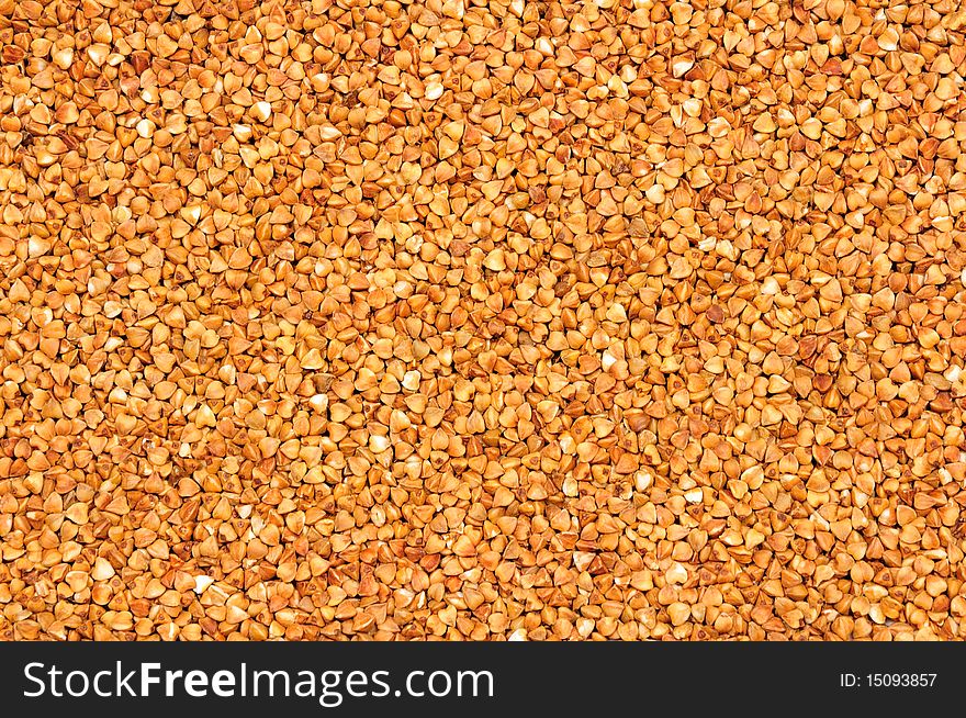 Background of natural small brown buckwheat groats. Background of natural small brown buckwheat groats