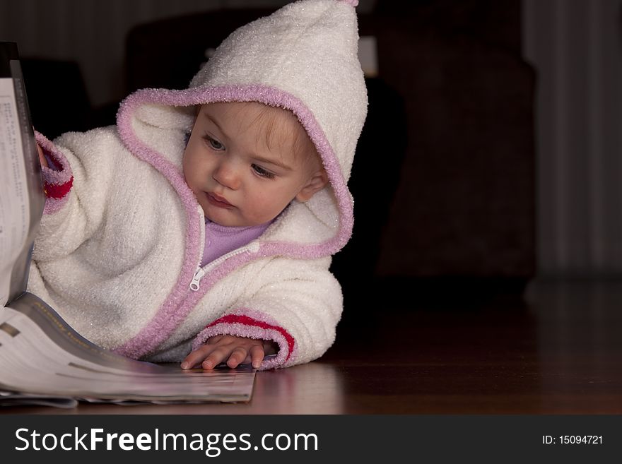 Small baby girl flipping through a magazine. Small baby girl flipping through a magazine