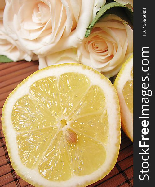 Fresh lemon and creamy roses isolated on wooden background