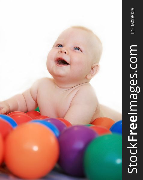 Beautiful white baby naked played with a little colored balls and smiles happily. Beautiful white baby naked played with a little colored balls and smiles happily