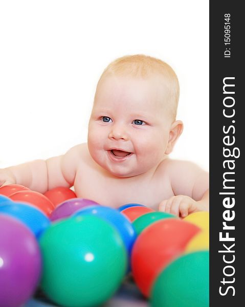 Beautiful white baby played with a little colored balls and smiles happily. Beautiful white baby played with a little colored balls and smiles happily