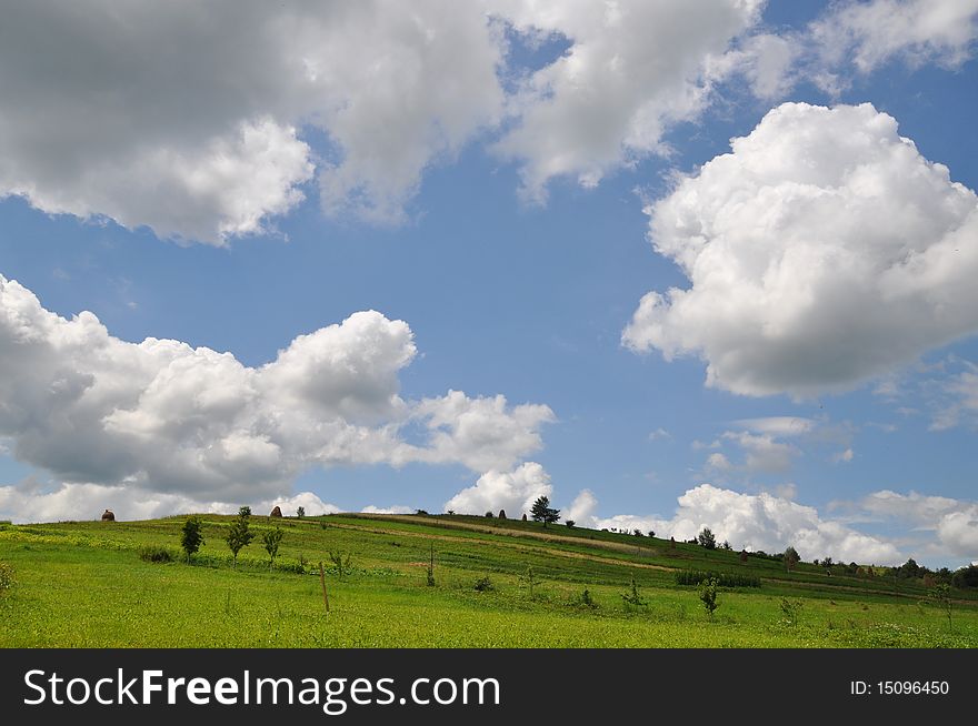 A summer hill in a rural landscape under white clouds. A summer hill in a rural landscape under white clouds.