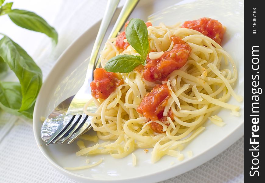 Spaghetti with a tomato sauce, cheese and a basil