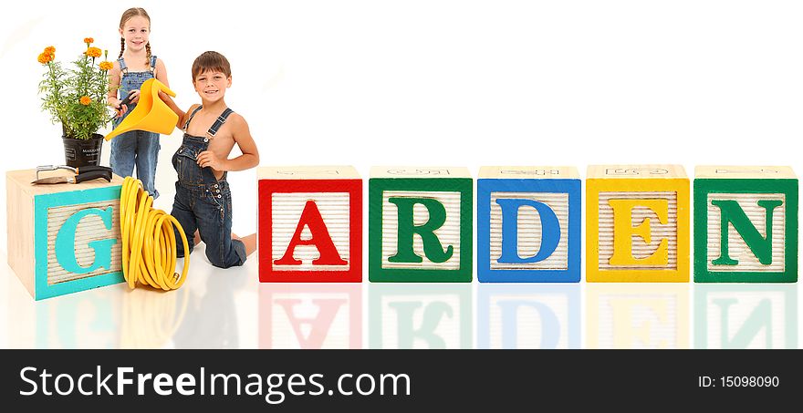 Attractive 5 and 6 year old brother and sister gardening with alphabet blocks. Attractive 5 and 6 year old brother and sister gardening with alphabet blocks.