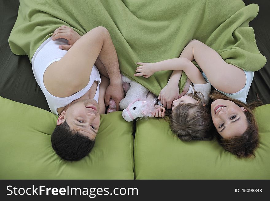 Happy young family at home relaxing in bed. Happy young family at home relaxing in bed