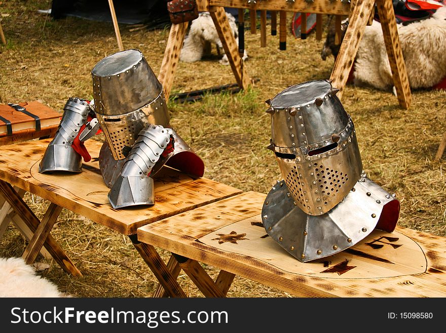 Detail of two medieval helmets arranget on a knight camp