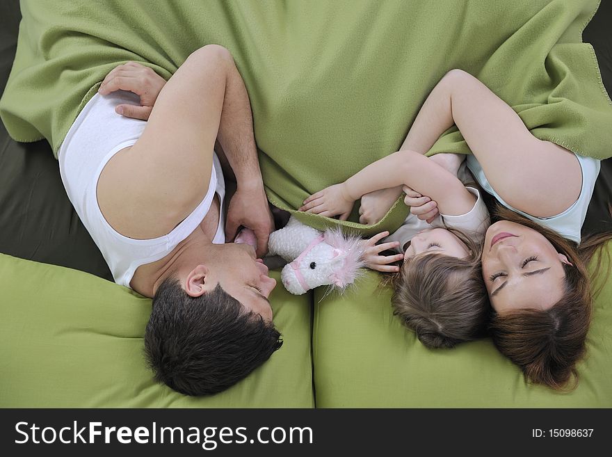 Happy young family at home relaxing in bed. Happy young family at home relaxing in bed