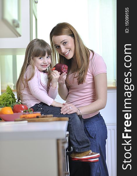 Happy young family have lunch time with fresh fruits and vegetable food in bright kitchen. Happy young family have lunch time with fresh fruits and vegetable food in bright kitchen