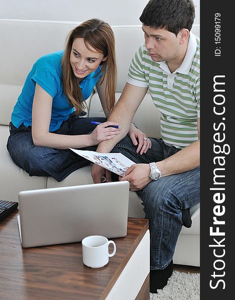 Young couple at home with  modern livingroom indoor working on laptop on house finance and planing. Young couple at home with  modern livingroom indoor working on laptop on house finance and planing