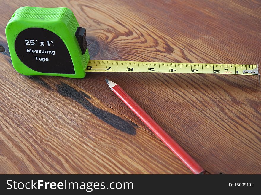 Measuring Tape and Pencil on a wooden table. Preparing to measure to biuld.