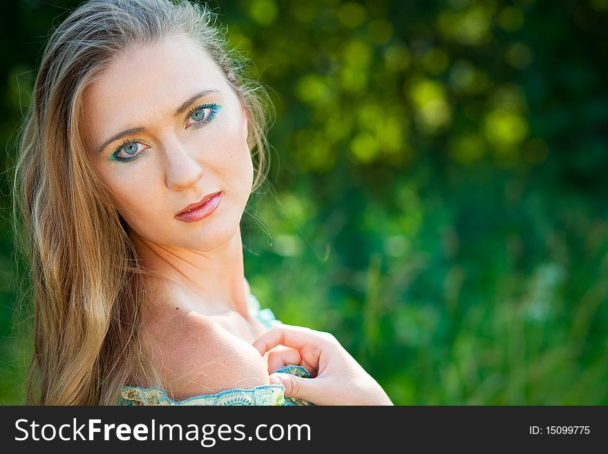 Beautiful woman among green leaves in the forest