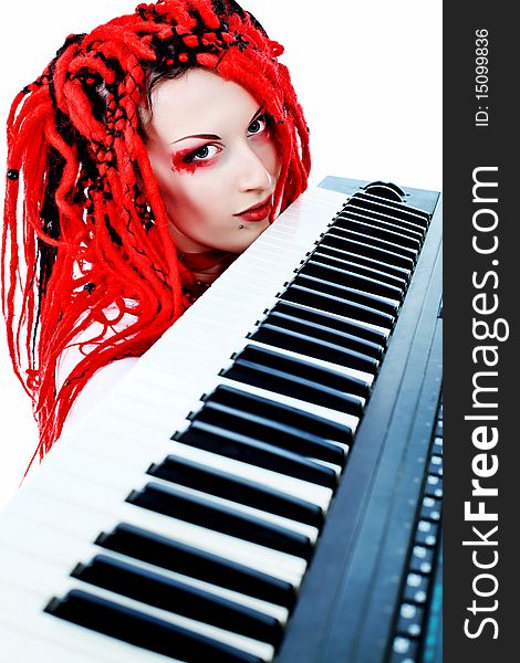 Rock musician is playing synthesizer. Shot in a studio.