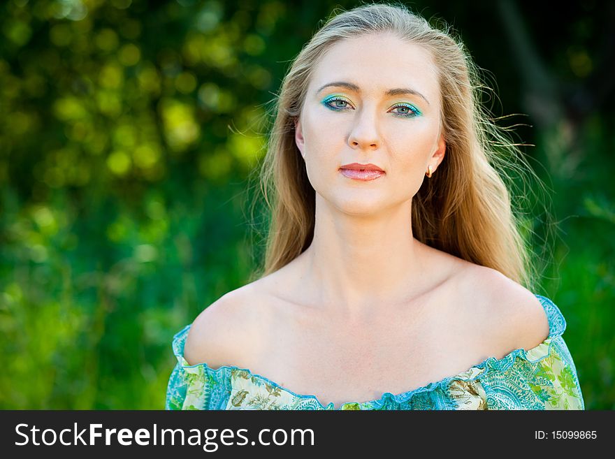 Beautiful woman among green leaves in the forest