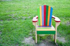 A Multi-colored Wooden Chair On The Playground. On The Background Of Green Grass Royalty Free Stock Image