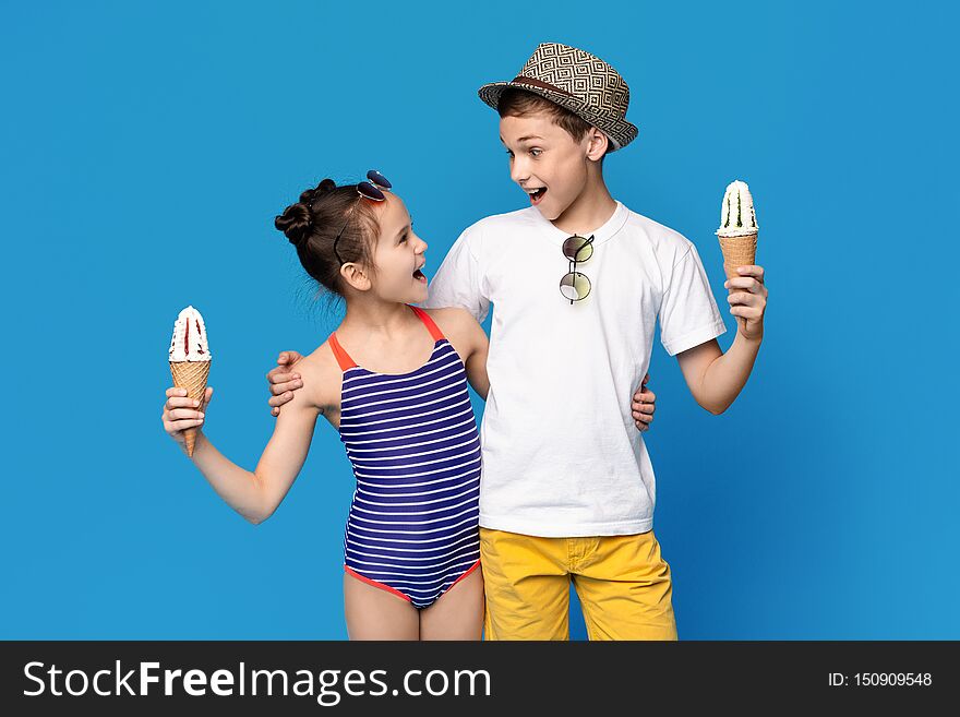 Excited Little Boy And Girl Embracing With Ice Cream Cones