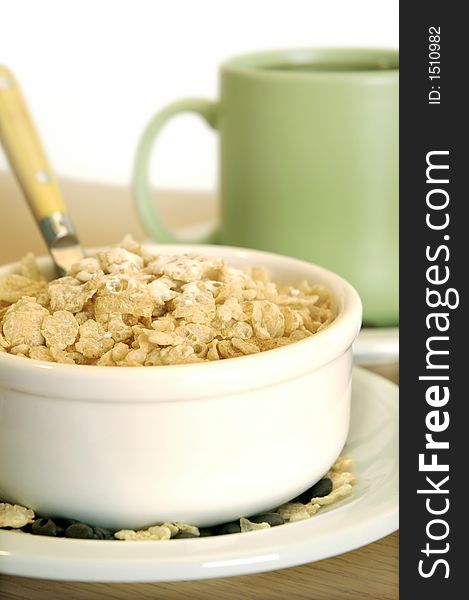 Bowl of cereal and coffee mug on table. Bowl of cereal and coffee mug on table