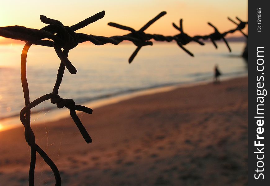 A sunset landascape with sea and barbedwire. A sunset landascape with sea and barbedwire