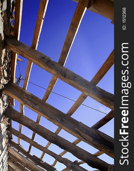 Old weathered roof construction frame under blue sky. Old weathered roof construction frame under blue sky