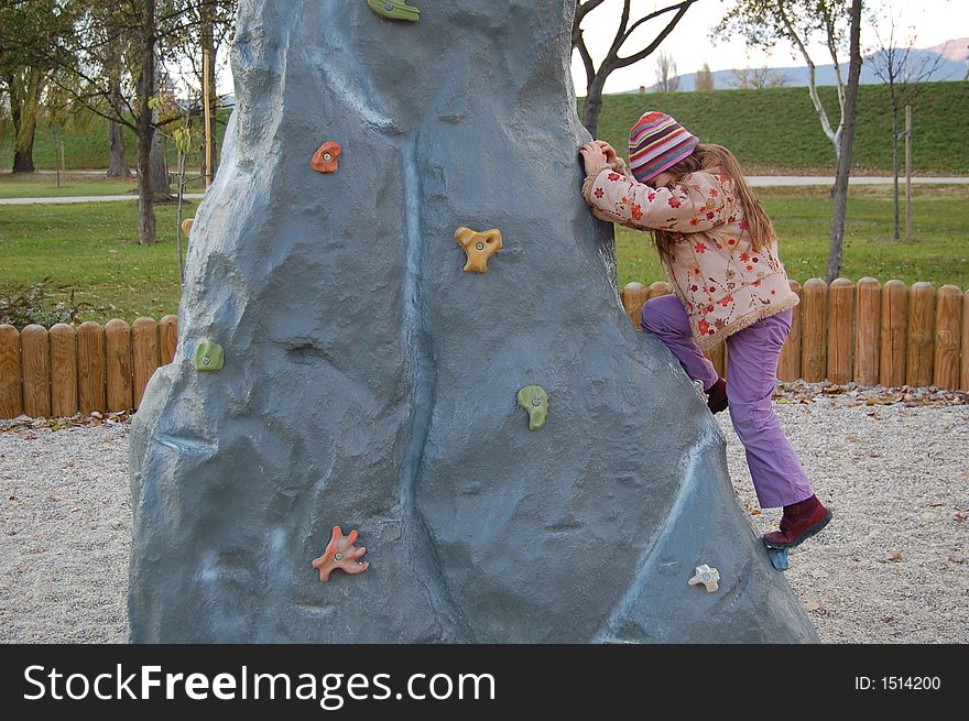 Child climbing a playground hill. Child climbing a playground hill.