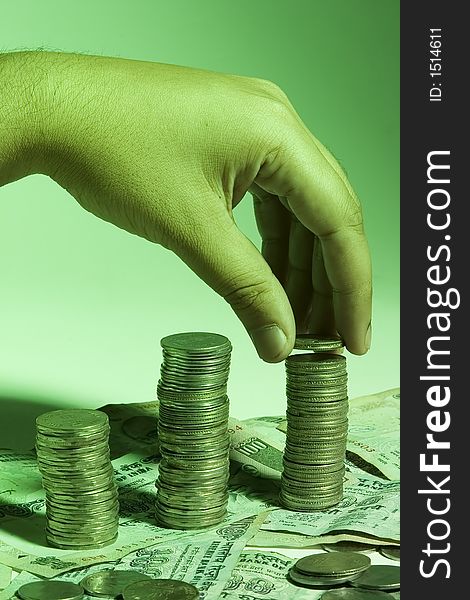 Man's hand placing coin on stack of change