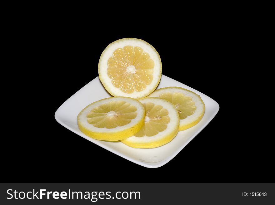 An isolated plate of sliced lemons. An isolated plate of sliced lemons