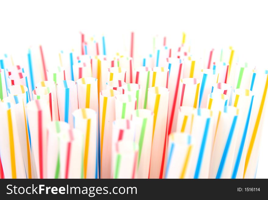 Assortment of colorful straws in a white glass