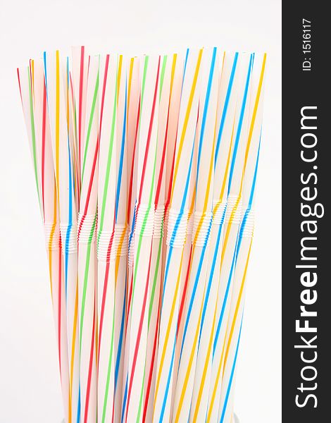 Assortment of colorful straws in a white glass