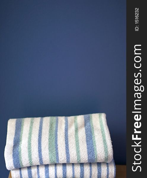 Two Stacked Towels together in front of a blue walled background