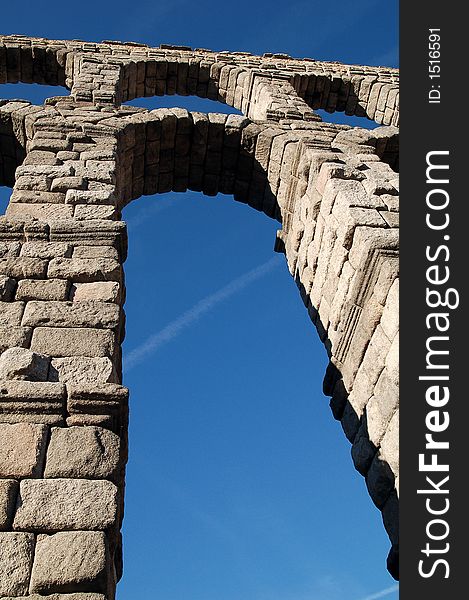 View of the Segovia's Roman aqueduct from underneath one of the arcs. View of the Segovia's Roman aqueduct from underneath one of the arcs