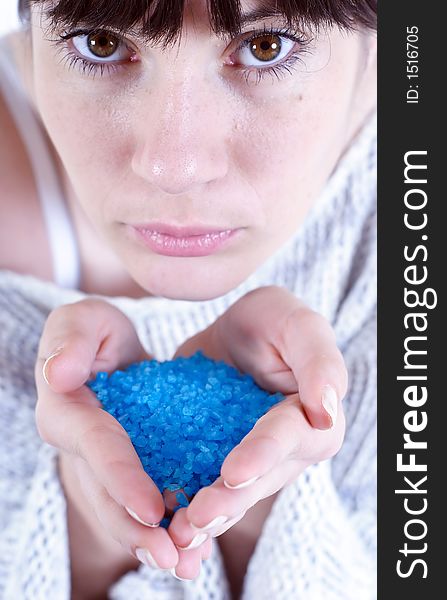 Stock photo of a young woman holding blue bath salt