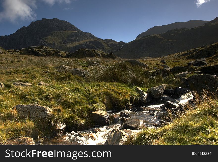 A mountain stream blocks the path upto Llyn Idwal, the Gribin Facet dominates the background.