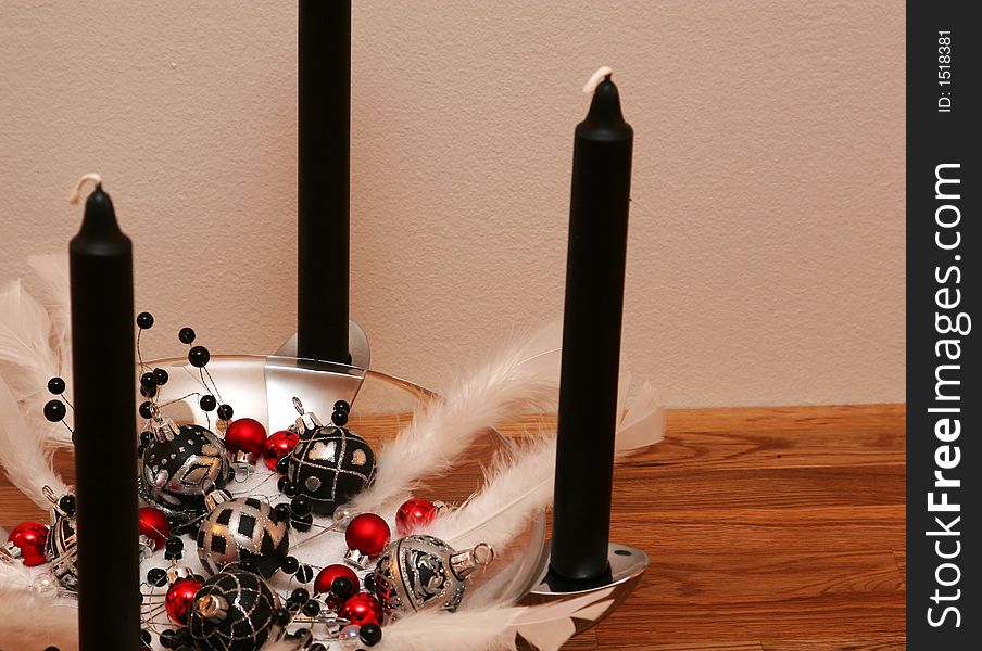 A black and white christmas decoration, with black candles and red balls. A black and white christmas decoration, with black candles and red balls