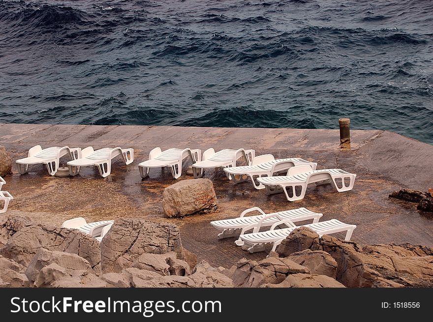 Bad weather on vacation - empty long chair on the beach