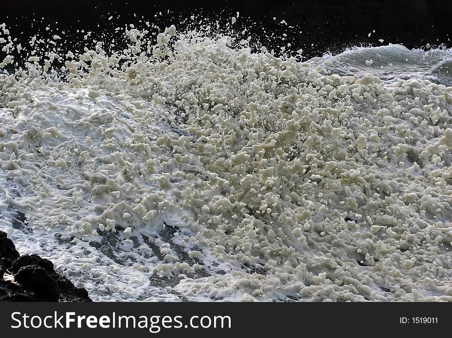 Sea foam flying off of a wild wave.