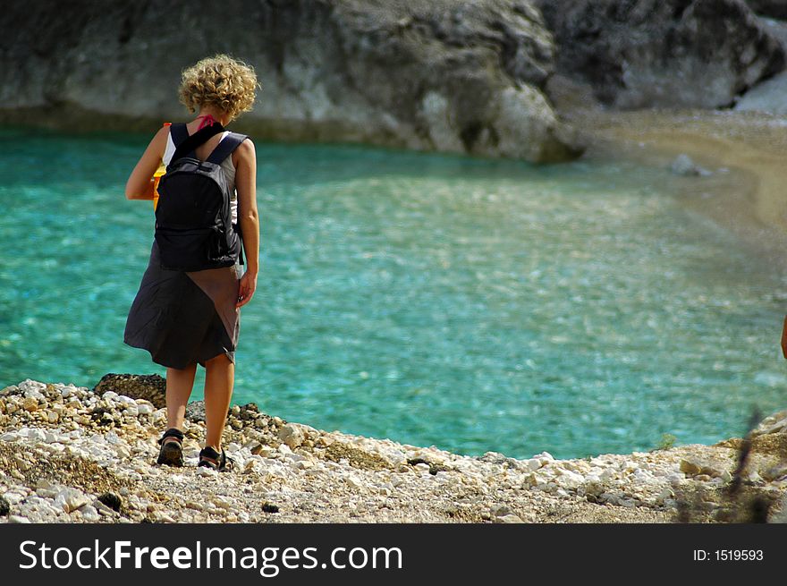 Alone girl in summer time goes on distant beach. Alone girl in summer time goes on distant beach