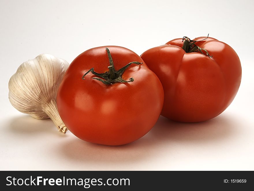 Fresh tomatoes and garlic on white background. Fresh tomatoes and garlic on white background