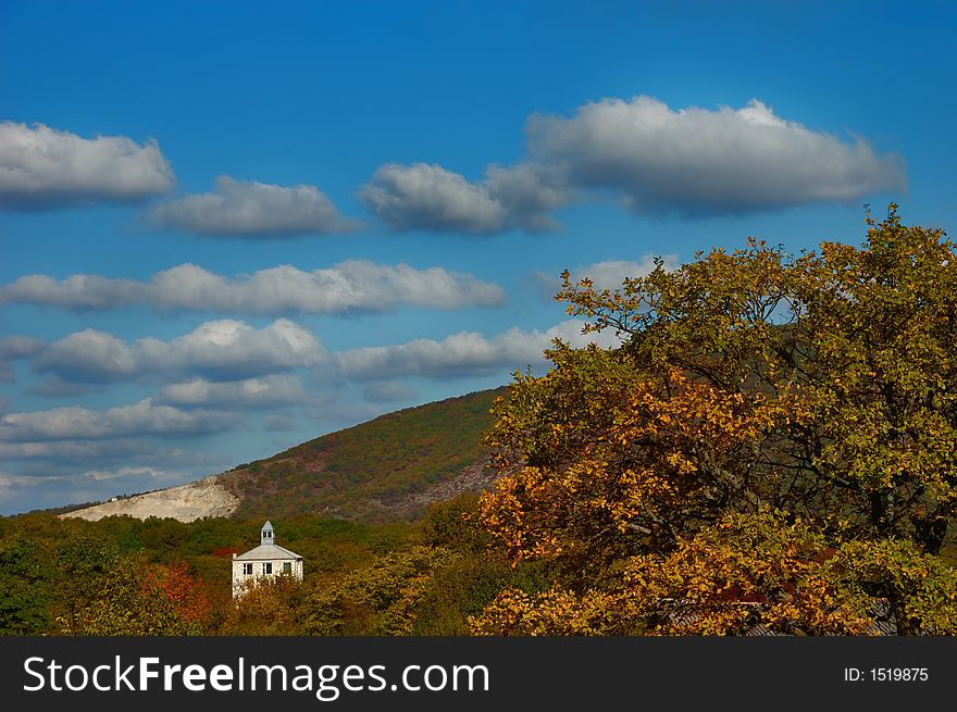 Hills in Eastern Crimea covered with autumn foliage against a blue cloudy sky. Hills in Eastern Crimea covered with autumn foliage against a blue cloudy sky