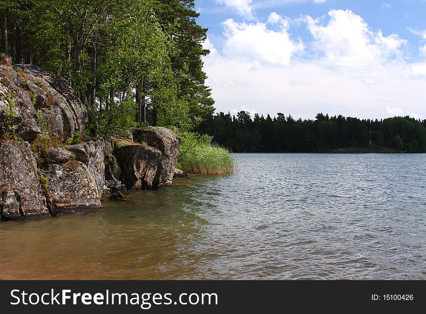 The nature of European northwest: a lake, the blue sky, rocks, pines, wood