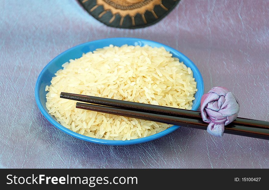Blue plate with uncooked rice and chopsticks. Blue plate with uncooked rice and chopsticks