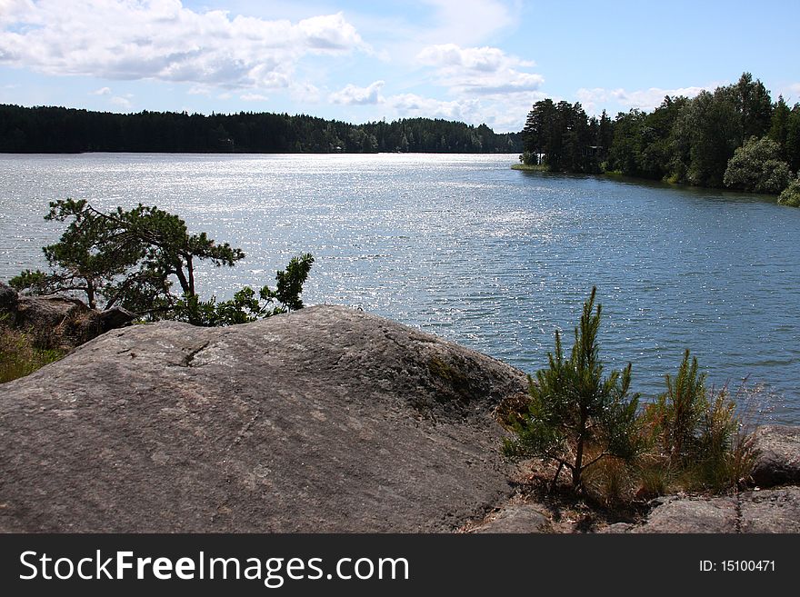 The nature of the European northwest: a lake, rock, wood, pines, blue sky