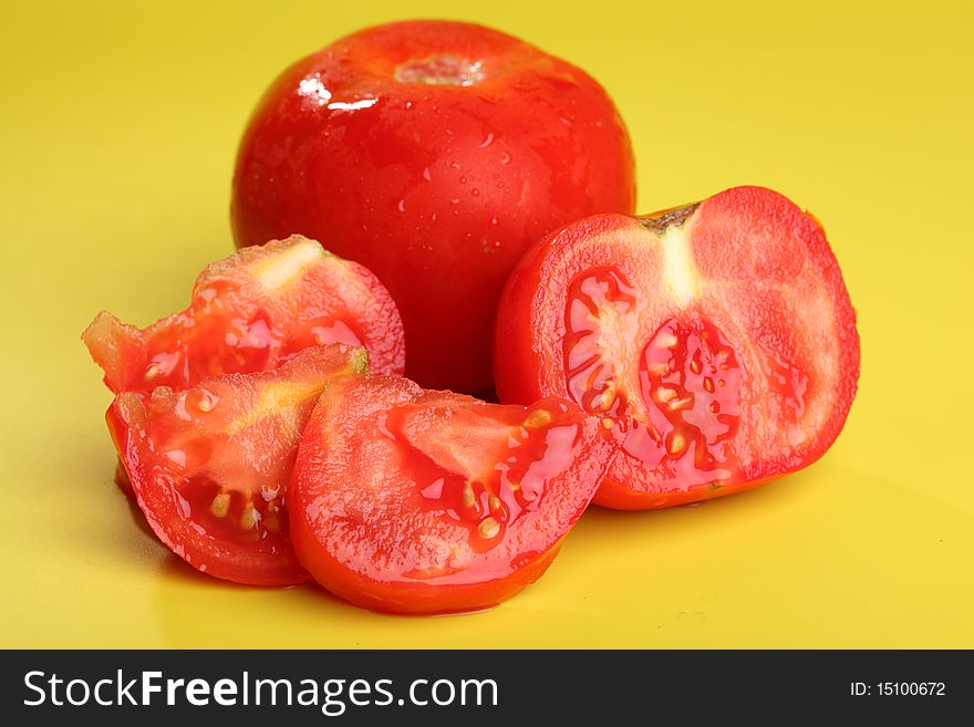 Fresh tomato (intact and sliced) with water drops on colored background. Fresh tomato (intact and sliced) with water drops on colored background