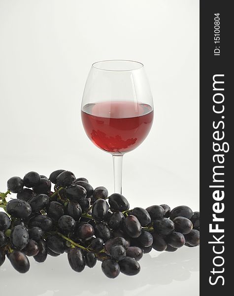 Red wine in a glass and red grape. Red wine in a glass and red grape.