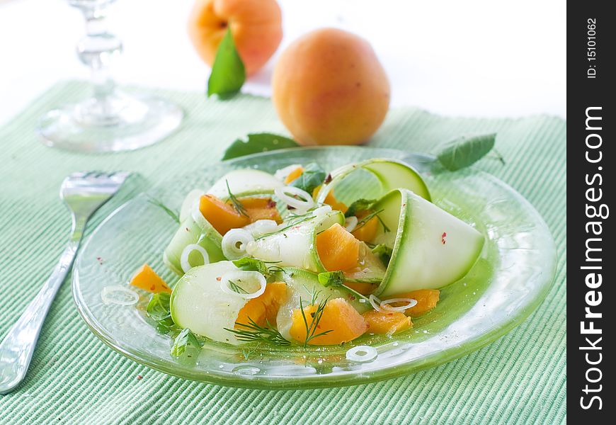Appetizer with zucchini and apricots, garnish with basil and onion on glass plate. Appetizer with zucchini and apricots, garnish with basil and onion on glass plate