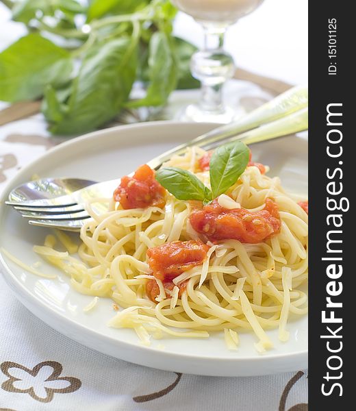 Spaghetti with a tomato sauce, cheese and a basil