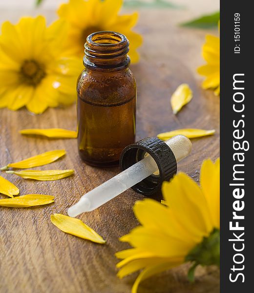 Essential oil bottle with yellow flower in background