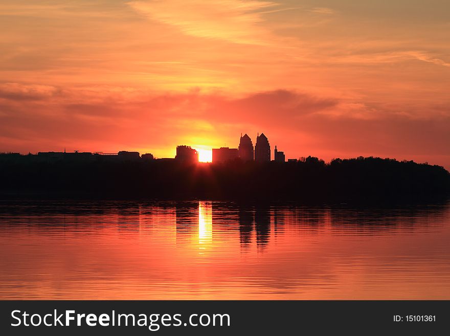 Cityscape of sunset scenery with building silhouette and river reflection. Cityscape of sunset scenery with building silhouette and river reflection