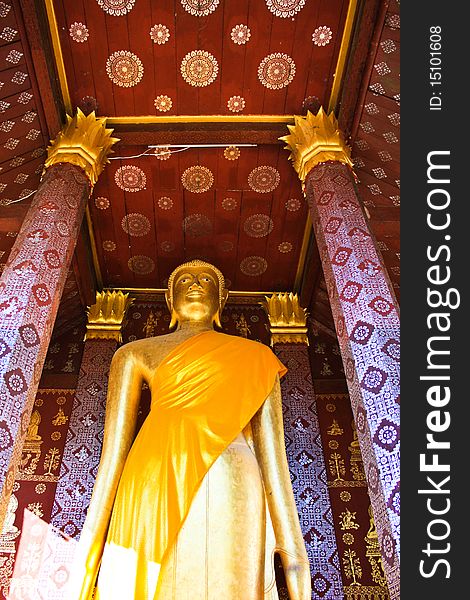 Tall Buddha image standing under beautiful ceiling of temple in Laos. Tall Buddha image standing under beautiful ceiling of temple in Laos