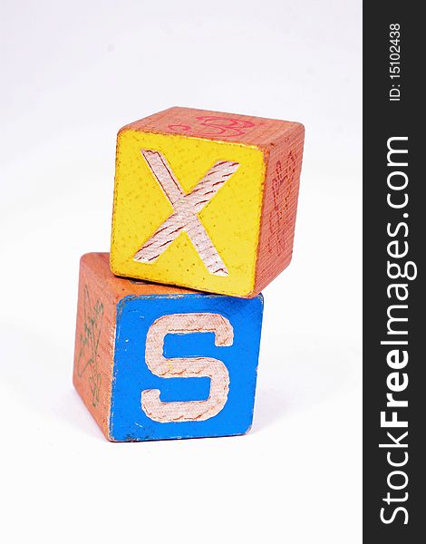 Two wooden blocks showing the letters X and S. Two wooden blocks showing the letters X and S