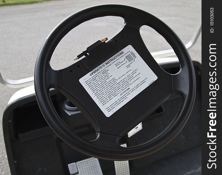 Steering wheel, with pencil and tee holders, on a golf cart. Steering wheel, with pencil and tee holders, on a golf cart
